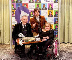 Andy Nicola, Chris Tait Burns reenactor, ella chambers pose with haggis at question of burns event