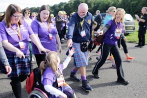Team Lucy are greeted by Sir Tom Hunter during the Kiltwalk