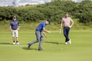 A gleeful golfer exclaims happiness at a successful golf shot