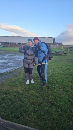 female charity supporter dressed in skydive gear with instructor. 