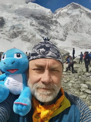 Mark Maclennan poses with spiney the Diney toy on Everest