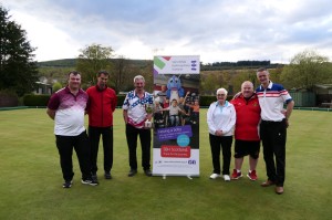 a group of 6 mean and women pose in front of an sbh scotland bannerstand in the middle of a bowling green