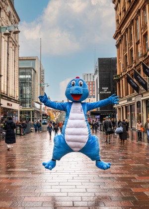 giant blue dinosaur doin star jump on Buchanan Street, Glasgow