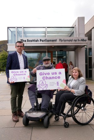 Lawrence Cowan, Amjid Majeed and Margo Whiteford are pictured outside Scottish Parliament with campaign signs saying 'Give us a Chance'