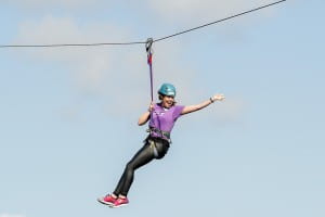 Happy girl zipslides across the clyde