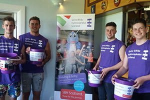 A group of men holding a can collection for SBH Scotland