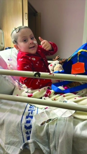 girl sat in hospital bed smiling